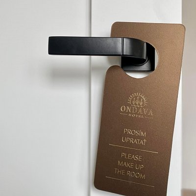 Visačka na dvere z kože Spectro so zlatou razbou loga.