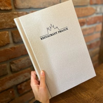Menu doska vyrobená zo strieborného kanvasu s nasúvacou lištou a razbou loga Restaurant Prague.